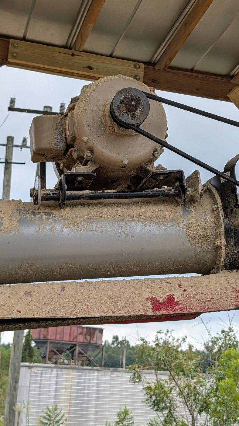 Close view of the top-mounted gearbox, sheave and open V-belt drive.