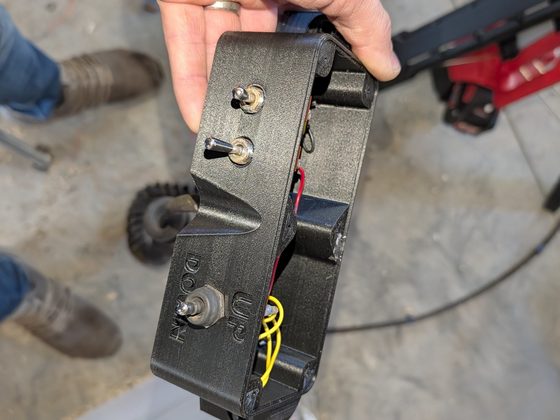 The printed two-button control enclosure held in a hand, with moulded UP and DOWN legends.