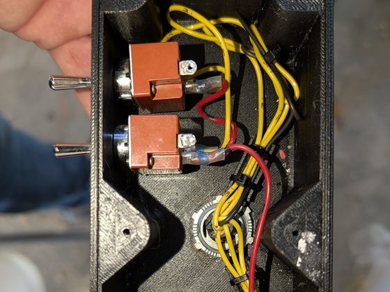Inside of the printed enclosure, showing internal ribbing, switches and a tied-down wiring loom.