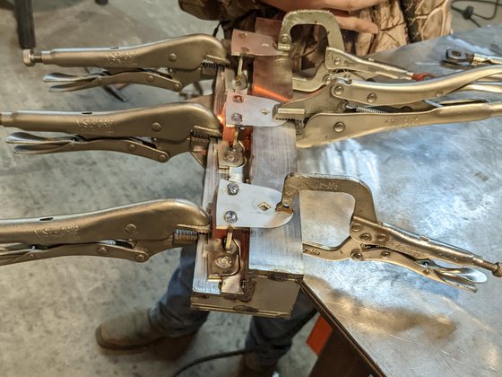 TIG welding a bearing bracket on the fixture, with copper backing and the arc live.